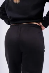 Pantalón de jogging negro con cintura elástica y cordón ajustable. Estampado con la palabra "GRAPHITE" en blanco en la pierna izquierda.