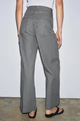 Jeans wide leg de tiro alto y diseño relaxed fit, confeccionados en denim azul marino con patrón de rayas verticales blancas. Cuenta con cinco bolsillos, cierre frontal con cremallera y botón, y detalle de nervio delantero con pespuntes a contraste.