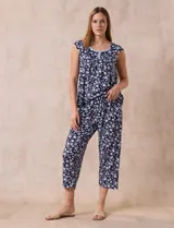 Conjunto de pijama marca René Rofé, compuesto por una remera de escote en V con botones y un pantalón capri con cintura elastizada, ambos en tejido soft estampado con motivos florales en tonos celeste y blanco.