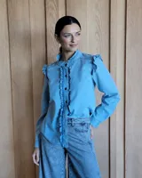 Camisa de denim celeste con cuello mao y volados en el frente y los hombros.