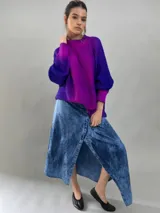 Buzo tejido de lana merino con diseño oversize, manga ranglan y cuello levemente elevado. Presenta un degradado de color vibrante en tonos violeta y fucsia.