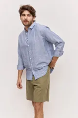 Camisa de manga larga de lino con diseño a rayas en tonos celestes y blancos, cuello camisero clásico y cierre frontal de botones.