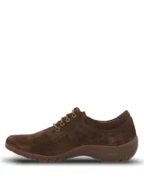 Zapato casual de mujer Hush Puppies modelo Rojam, confeccionado en cuero gamuzado color marrón. Presenta cierre mediante cordones al tono, suela de goma flexible y detalle de logo metálico en el lateral.