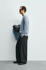 Pantalón de corte wide fit confeccionado en algodón con efecto lavado. Presenta pliegues frontales, bolsillos laterales y bolsillos traseros de vivo. Cierre frontal con cremallera y gancho metálico oculto.