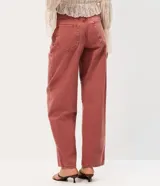 Pantalón baggy de sarga de algodón color rosado, con cintura media, bolsillos funcionales y ajuste mediante botón y cierre.