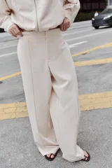 Pantalón de tiro alto con pernera recta y nervio marcado en el delantero. Cuenta con cintura elástica en la parte posterior, bolsillos delanteros y bolsillos de plastrón en la parte trasera. Cierre frontal con botón interior y ganchos.