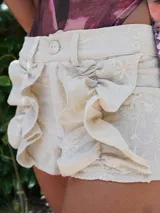 Shorts de tiro bajo de lino con diseño bordado y volados frontales.
