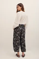 Pantalón tipo babucha de algodón, con estampado floral en tonos oscuros y diseño holgado.