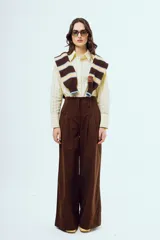 Pantalón marrón de corte ancho y talle alto, con pinzas frontales y bolsillos laterales.