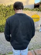 Buzo negro de algodón con cuello redondo y logo bordado en el pecho.