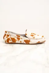 Mocasines de cuero con animal print de vaca en tonos blanco y marrón.