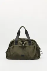 Bolso de nylon en color verde militar, con diseño deportivo, asas de mano resistentes, cierre superior y bolsillos laterales con frunce ajustable mediante cordón elástico.