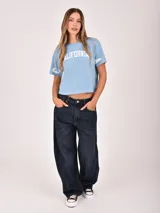 Remera negra de manga corta con estampado frontal que dice "WEST COAST California" en blanco y detalles gráficos en las mangas.