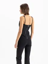 Top de lycra doble color negro, de calce ajustado y largo hasta la cadera. Presenta recortes de entalle en el delantero y la espalda, escote recto y breteles con detalle de cintas formando moños.