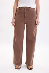 Pantalón jean ancho y elastizado en color marrón, de corte recto y tiro medio, con bolsillos y trabillas para cinto.