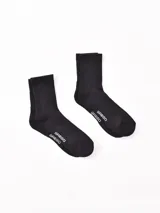 Pack de dos pares de medias negras de caña corta con logo de la marca en el tobillo.