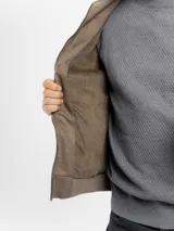 Campera de estilo casual confeccionada en tejido suave con textura tipo gamuza. Presenta cuello alto, cierre frontal, bolsillos laterales y bolsillos frontales con solapa. Incluye detalles de costuras en las mangas y terminaciones elastizadas en puños y cintura.