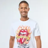 Camiseta blanca de manga corta con estampado frontal de la icónica lengua y labios de The Rolling Stones rodeada de llamas, con una cinta que dice "Tattoo You" y el nombre de la banda en tipografía manuscrita.