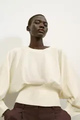 Jersey de cuello redondo color blanco, con manga larga tipo murciélago y acabados en rib elástico.