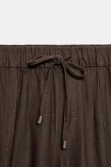 Pantalón jogger de tiro bajo color marrón, con cintura elástica ajustable con cordón, bolsillos delanteros y puños elásticos en los tobillos.