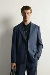 Blazer regular fit azul marino confeccionada en tejido con 20% de lana. Cuenta con cuello con solapas de muesca, manga larga con botones en los puños, bolsillos de vivo en el pecho y de solapa en la cadera, y cierre frontal con botones.
