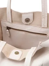 Cartera tipo shopper de cuero color crudo, sin forro y con terminaciones al corte. Presenta gran capacidad y un bolsillo interior con cierre.