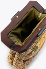 Bolso de mano tipo clutch confeccionado en rafia color beige con asa de madera oscura y cierre a presión. Decorado con dos peces bordados con cuentas y rafia de colores amarillo, marrón y verde.