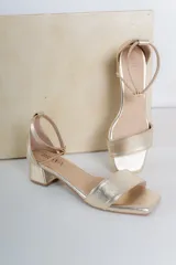 Sandalias doradas de cuero vegano con punta cuadrada y taco bajo.