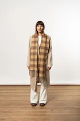 Bufanda larga color beige y marrón con estampado de cuadros y flecos en los extremos.