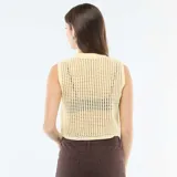 Top sin mangas de tejido de punto tipo crochet, color amarillo pastel, con cuello redondo y diseño calado.