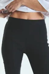 Calza negra de lycra gruesa, tiro alto y corte semi-oxford con abertura en el tobillo.