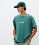 Remera de algodón con efecto lavado gastado, cuello redondo y mangas cortas. Presenta un diseño con estampa frontal localizada con lettering West Coast y un calce levemente suelto.