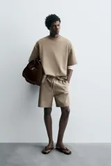 Sudadera de manga corta color marrón oscuro, con cuello redondo y bajo acabado en rib. Presenta un corte relajado y holgado (boxy fit).