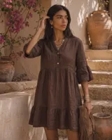 Vestido corto marrón de lino, con cuello mao, escote en V con botones, mangas tres cuartos con volados y diseño en capas con frunces.