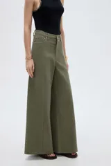 Pantalón jean verde militar, de tiro alto, corte ancho tipo wide leg y diseño de perneras amplias con costuras verticales decorativas.