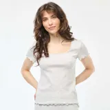 Camiseta gris de punto canalé, de manga corta y escote cuadrado con ribete ondulado.