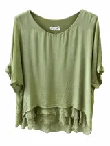 Blusa verde pistacho de corte holgado, diseño en capas con dobladillo desmechado y mangas cortas amplias.