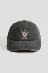 Gorra gris oscuro con efecto lavado, visera curva y bordado frontal con el texto "Sport League Chicago" y un emblema circular.