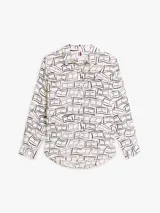 Camisa Tommy Hilfiger de corte amplio confeccionada en lino puro, con diseño estampado de líneas geométricas en azul sobre base blanca. Presenta cuello inglés, cierre frontal abotonado, mangas largas con puños abotonados y logo bordado en el pecho.