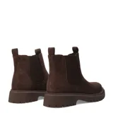Botas Chelsea de mujer color marrón oscuro, estilo botín, con caña corta y paneles elásticos laterales. Cuentan con suela track gruesa y tiradores en el talón y la abertura frontal para facilitar el calce.