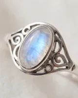Anillo de plata 925 con piedra de la luna ovalada y detalles de filigrana en los laterales.