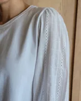 Remera de algodón con cuello redondo y mangas abullonadas de textura diferenciada. Presenta un diseño versátil con cuerpo de algodón y mangas de tussor al tono.