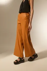 Pantalon de tiro alto confeccionado en eco-cuero, con diseño de pierna ancha y corte recto.