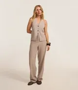 Pantalón de vestir color beige, de corte recto, confeccionado en crepé. Cuenta con cintura fija, bolsillos laterales tipo cuchillo y cierre frontal oculto.