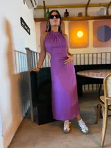 Vestido midi lila con cuello halter y aberturas laterales en la cintura.