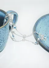 Collar de cadena plateada con perlas sintéticas y dijes de ojo turco.