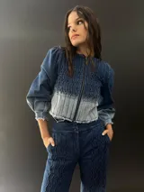 Campera de jean azul con lavado artesanal, entallada y corta hasta la cintura alta. Presenta textura central en el delantero.