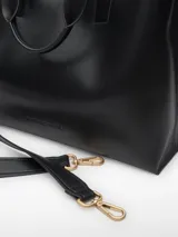 Bolso shopper horizontal de poliuretano color beige, con dos compartimentos, cierre magnético, bolsillo interior con cierre, asa de mano y asa larga regulable y extraíble. Incluye logo grabado en el frente.