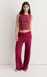 Pantalón de fibrana color bordó con elástico en la cintura y corte ancho. Presenta un estampado sutil de líneas verticales y horizontales en tonos oscuros.