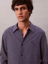 Camisa de manga larga Calvin Klein con estampado de rayas verticales finas, cuello camisero y cierre frontal con botones.